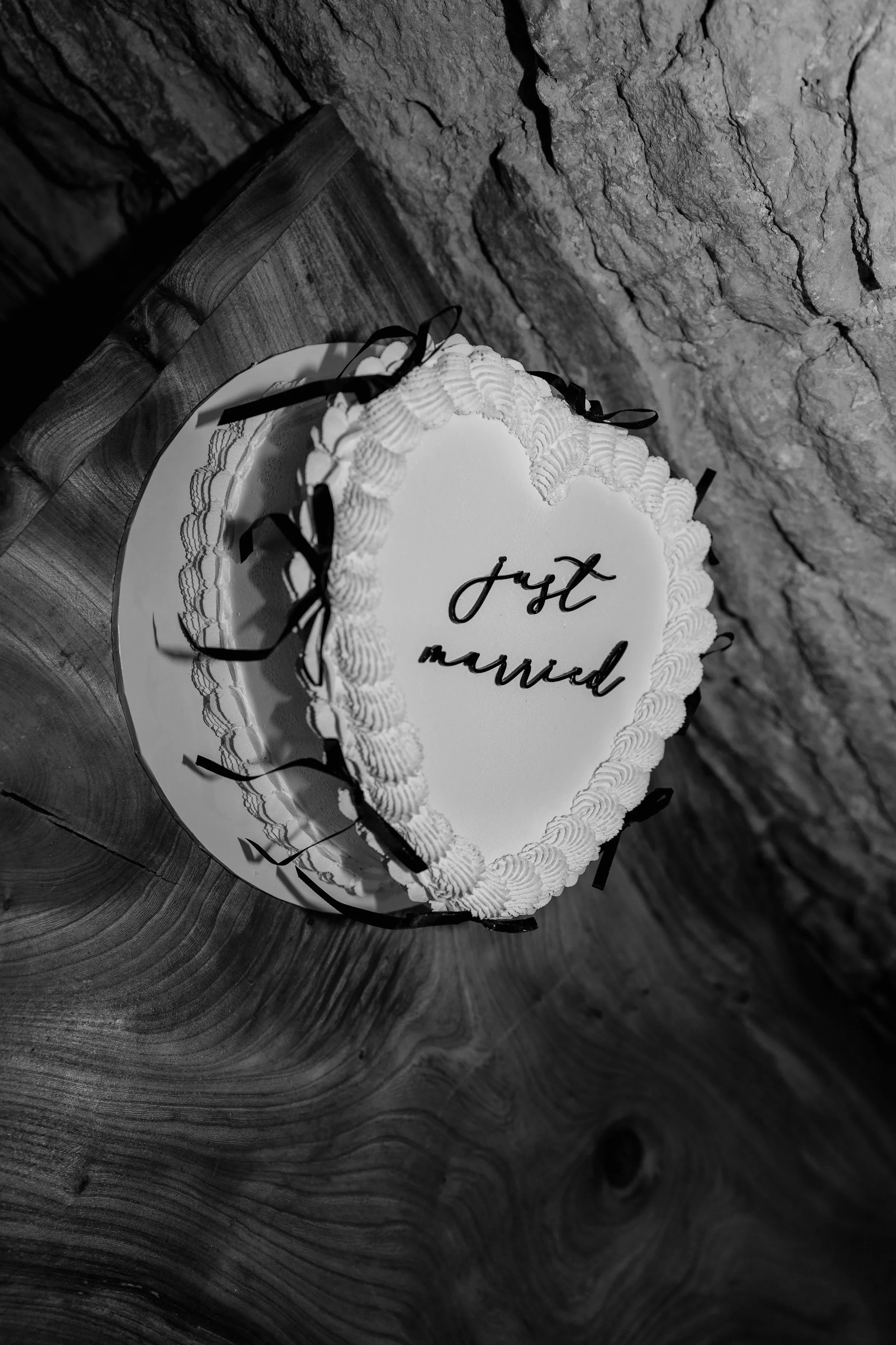 Black and white wedding cake detail photograph with ‘just married’ icing, captured during a Somerset wedding