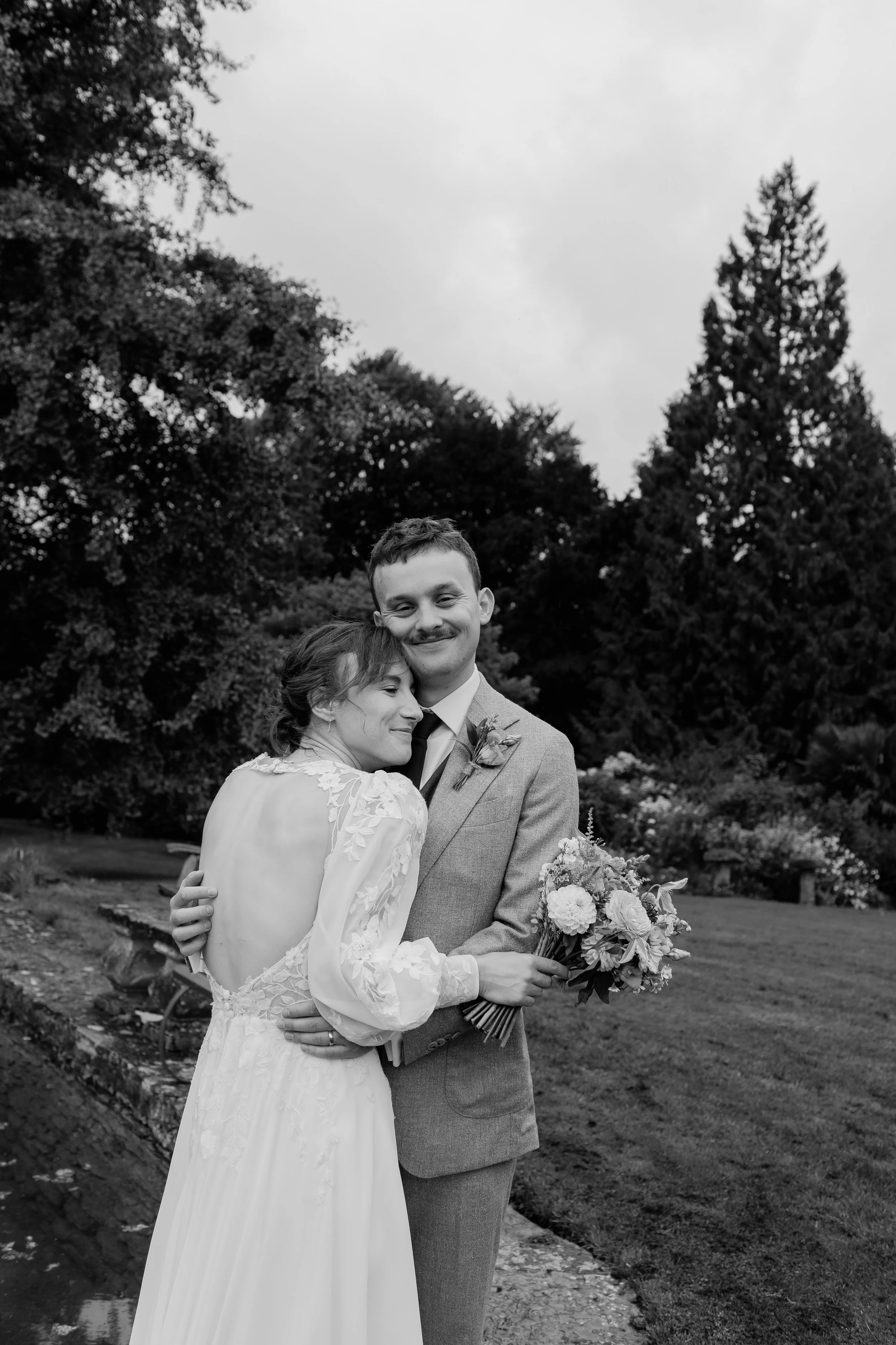Bride and groom embracing during a relaxed outdoor wedding portrait at a Somerset country house wedding venue.
