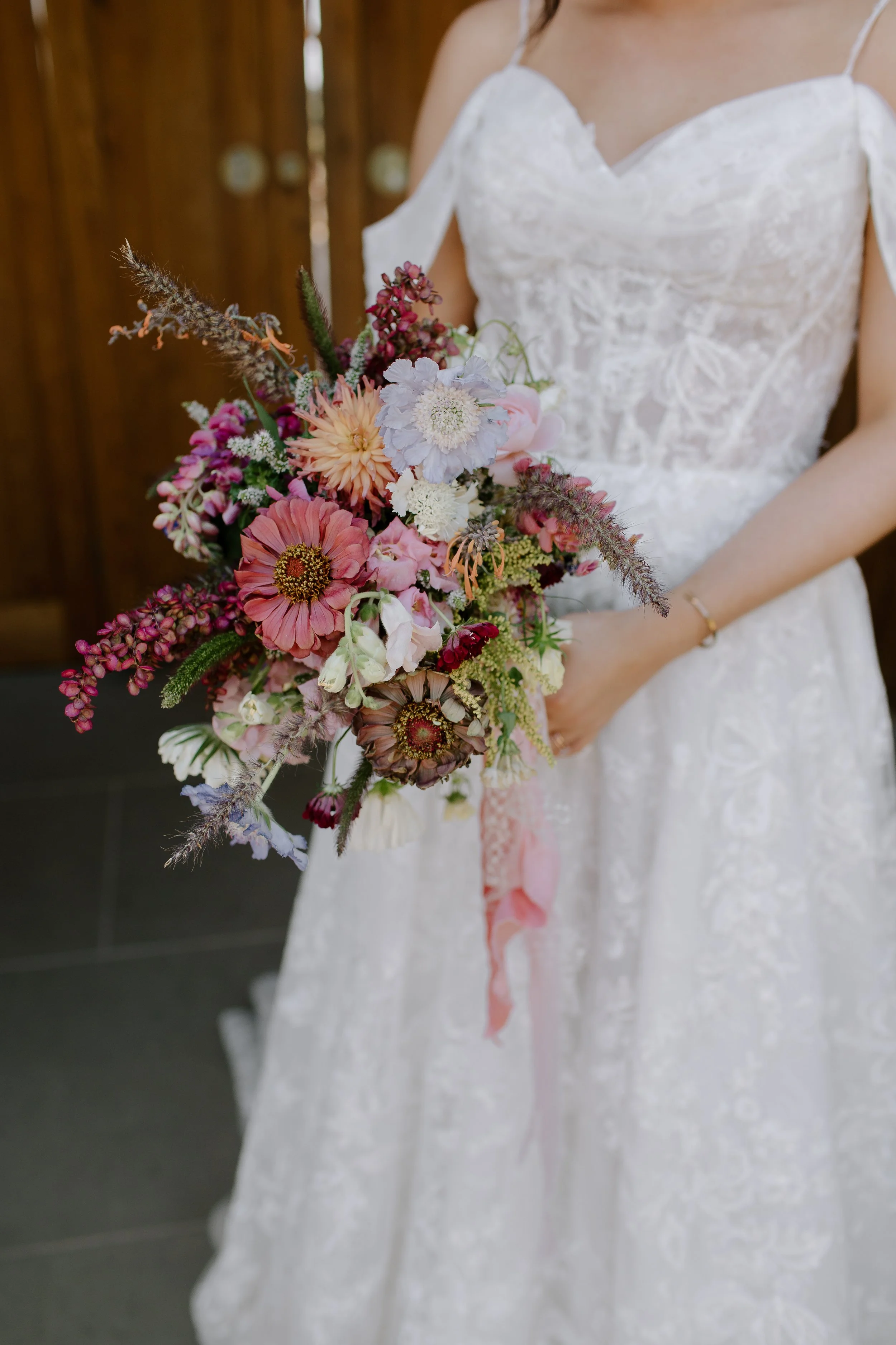Bride holding a colourful wildflower wedding bouquet during a Somerset country house wedding.