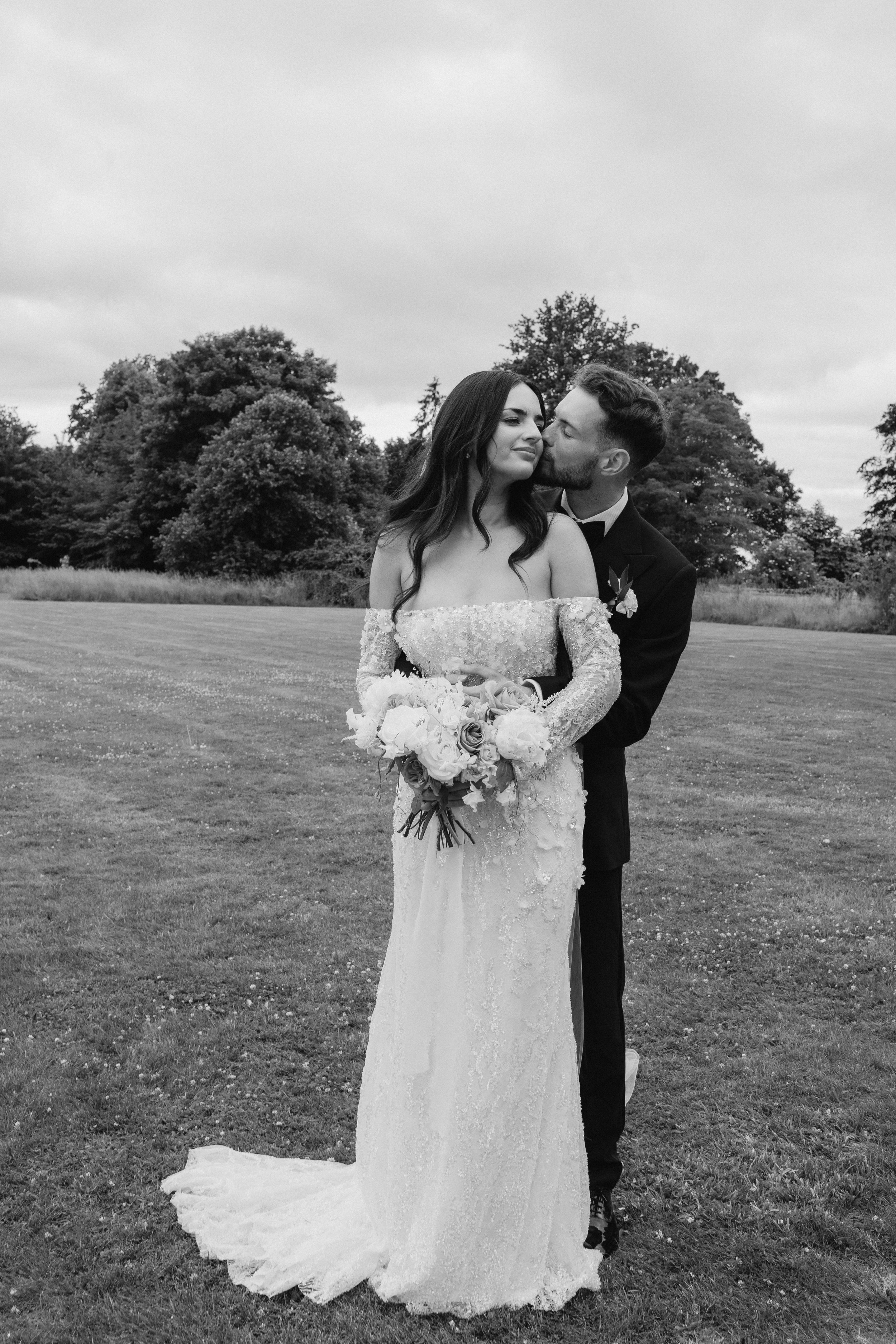 Bride and groom embracing during a relaxed outdoor wedding portrait at a Somerset country house wedding venue.