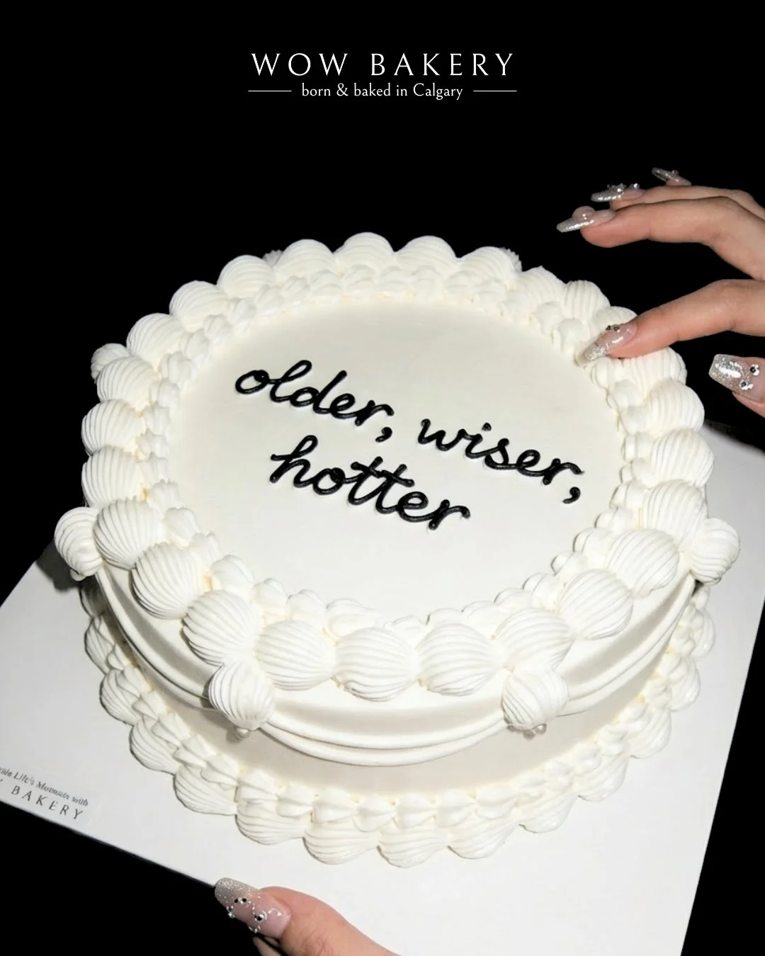 White vintage lettering cake with black handwritten message and piped cream border