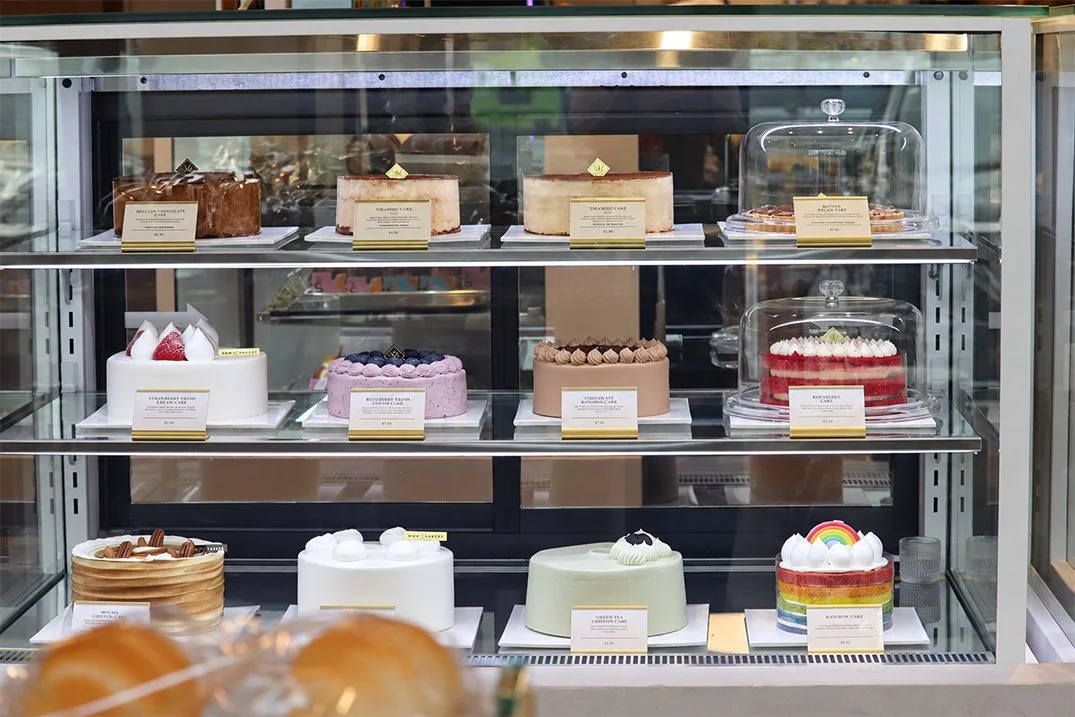 A colourful selection of whole cakes displayed at WOW Bakery West Springs in Calgary.