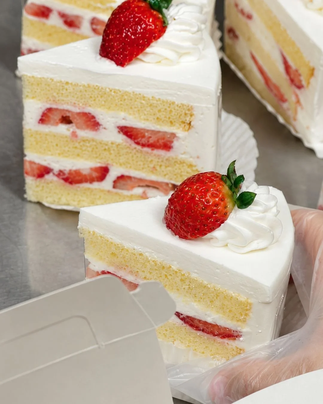 WOW Bakery’s Strawberry Fresh Cream cake slices being boxed for customers at the West Springs grand opening.