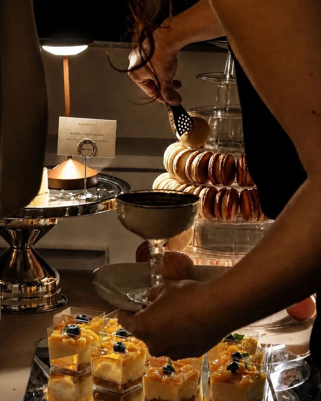 Guests enjoying WOW Bakery mango mousse beside a macaron tower at a Calgary wedding event