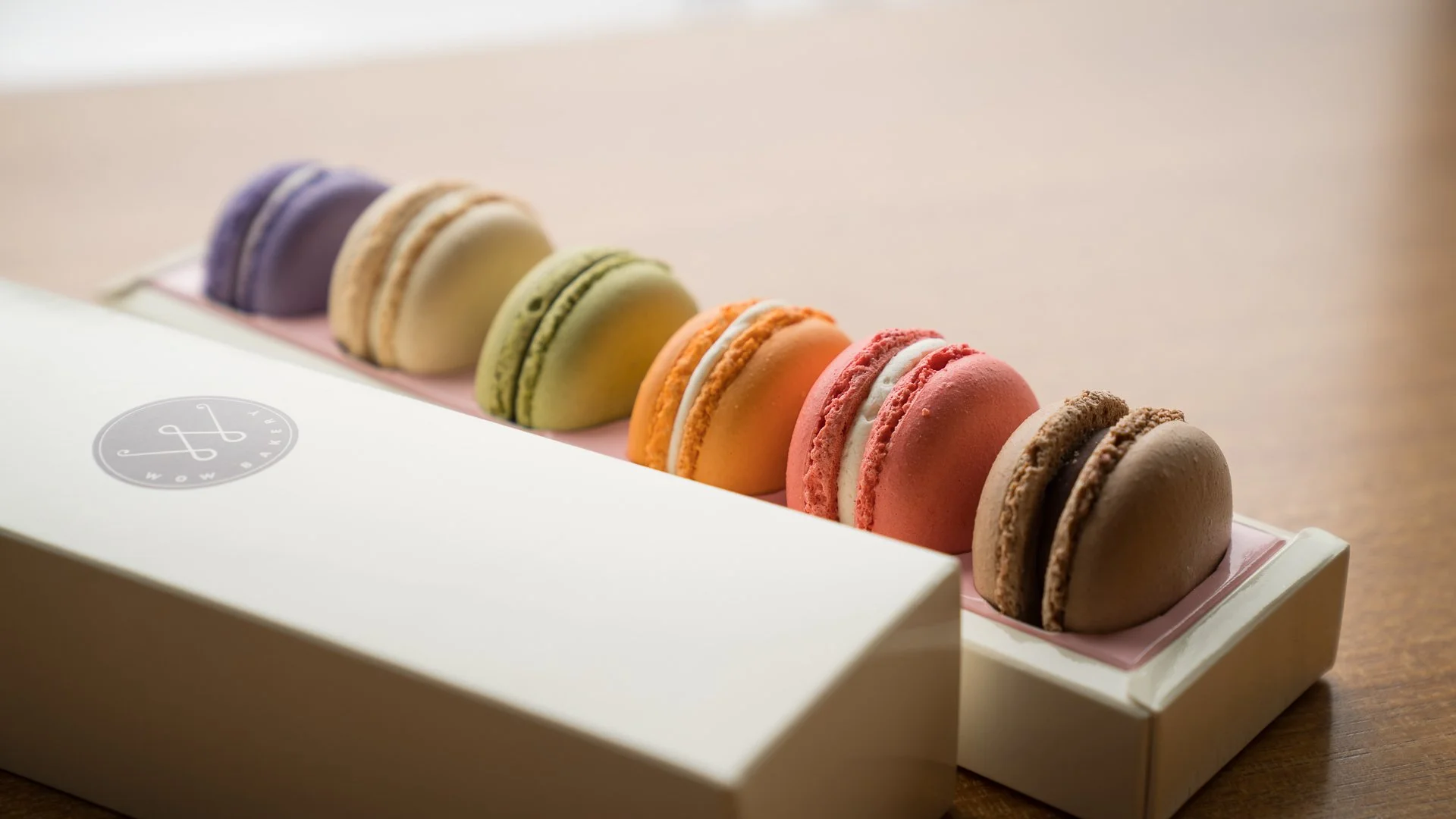 Assorted colorful macarons arranged in a gift box from WOW Bakery.