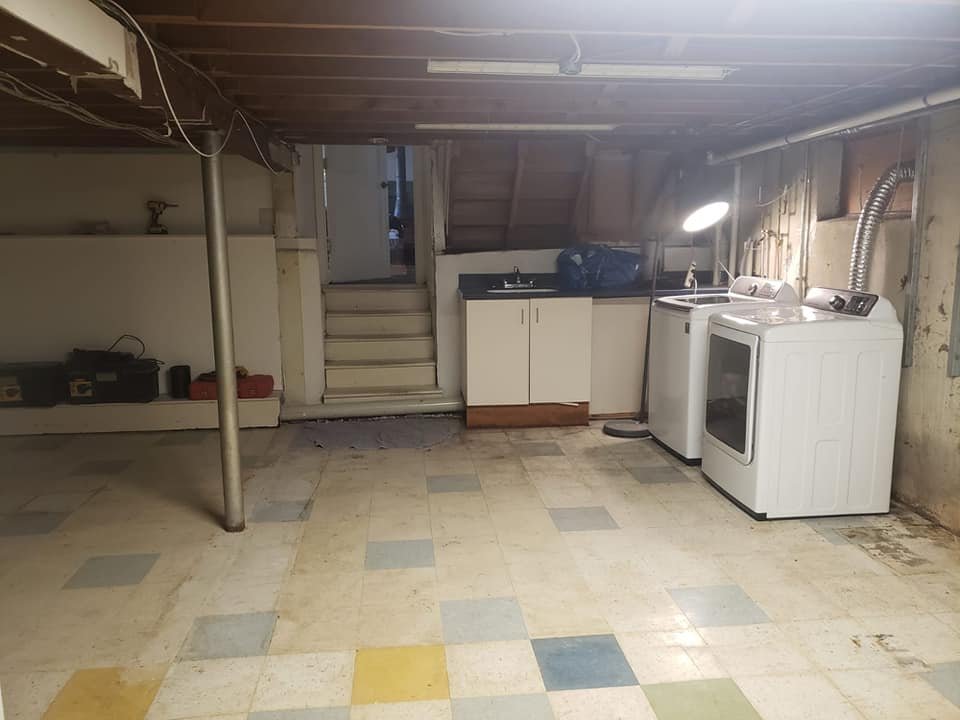 Laundry room with washer and dryer, sink, cabinet, and step stairs leading to another room.