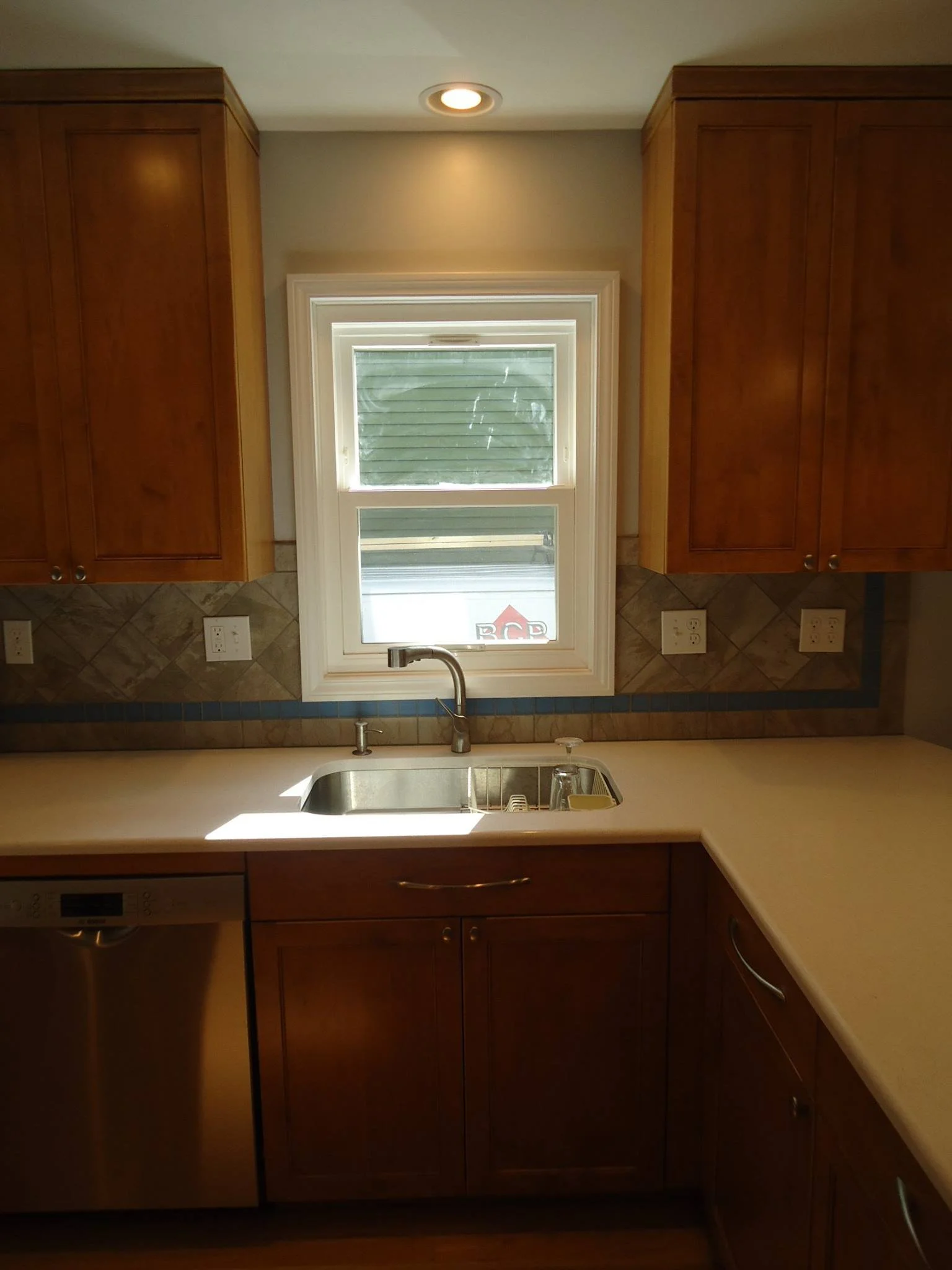 Kitchen with wooden cabinets, a window above the sink, and a countertop.