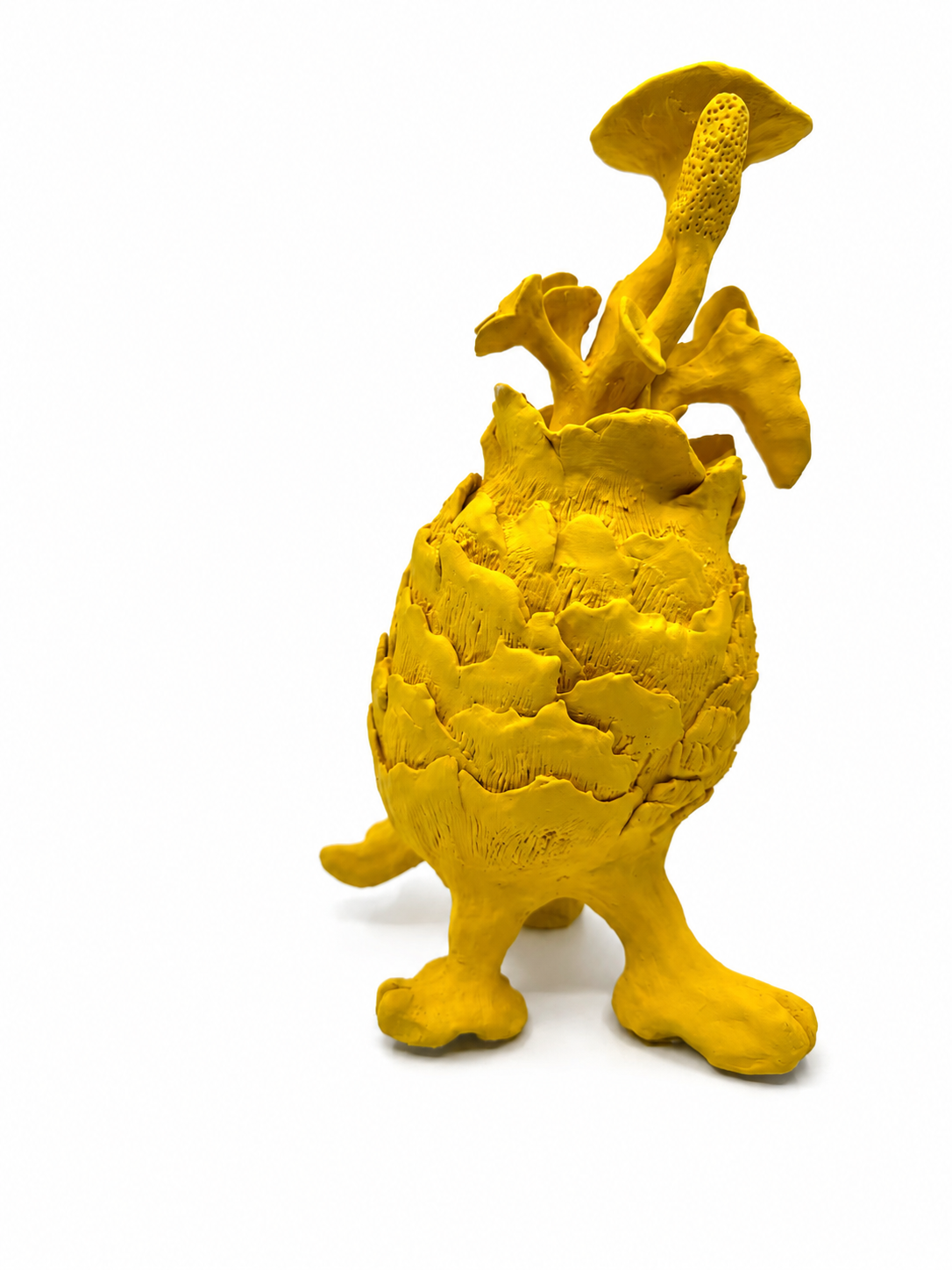Yellow sculpture resembling a pineapple with mushroom-like structures on top, set against a plain white background.