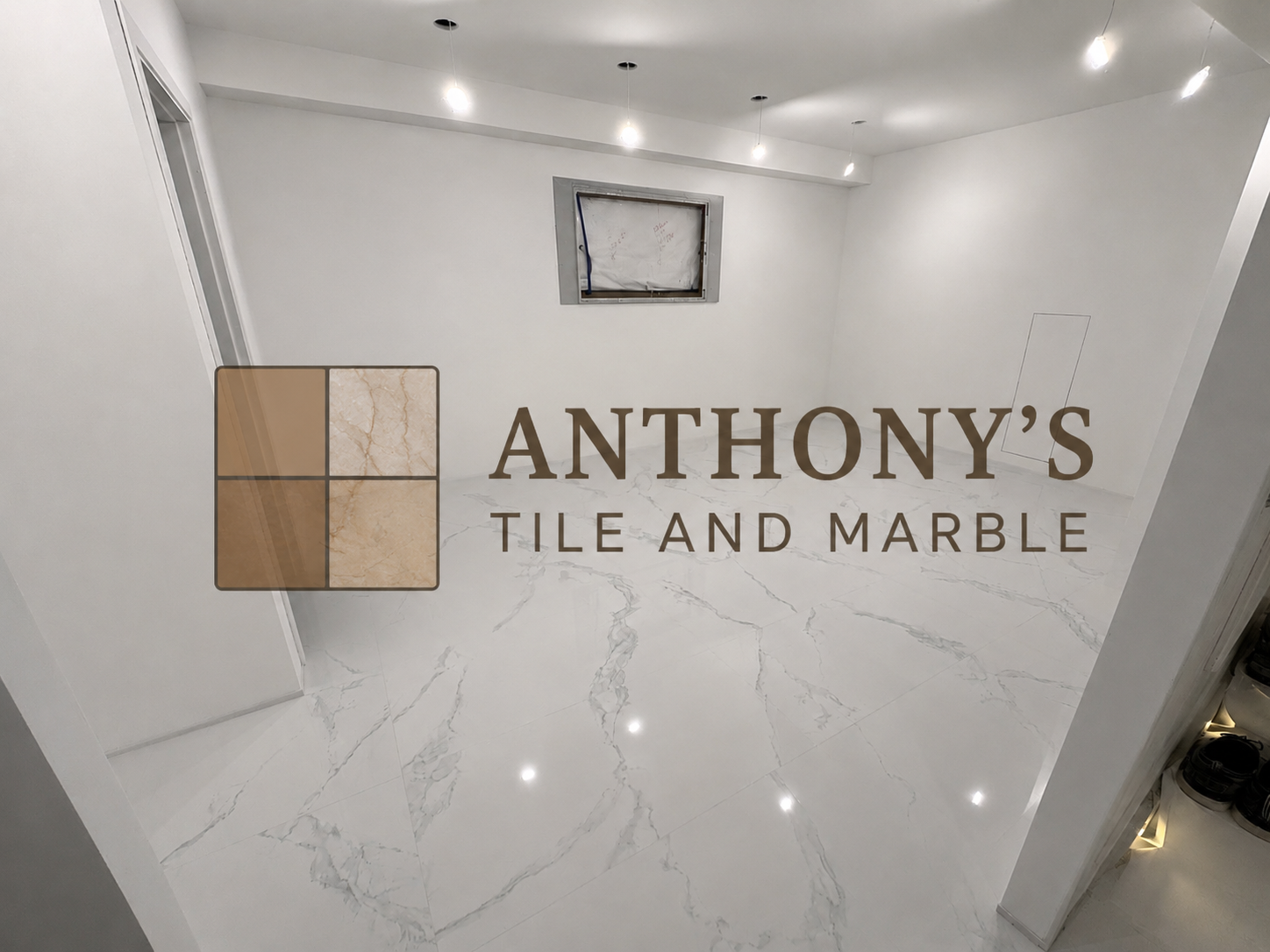 Empty room with white marble tile floor, white walls, and recessed ceiling lights. The window is covered, and the doorframe is visible on the left. The logo of Anthony's Tile and Marble is superimposed on the image.
