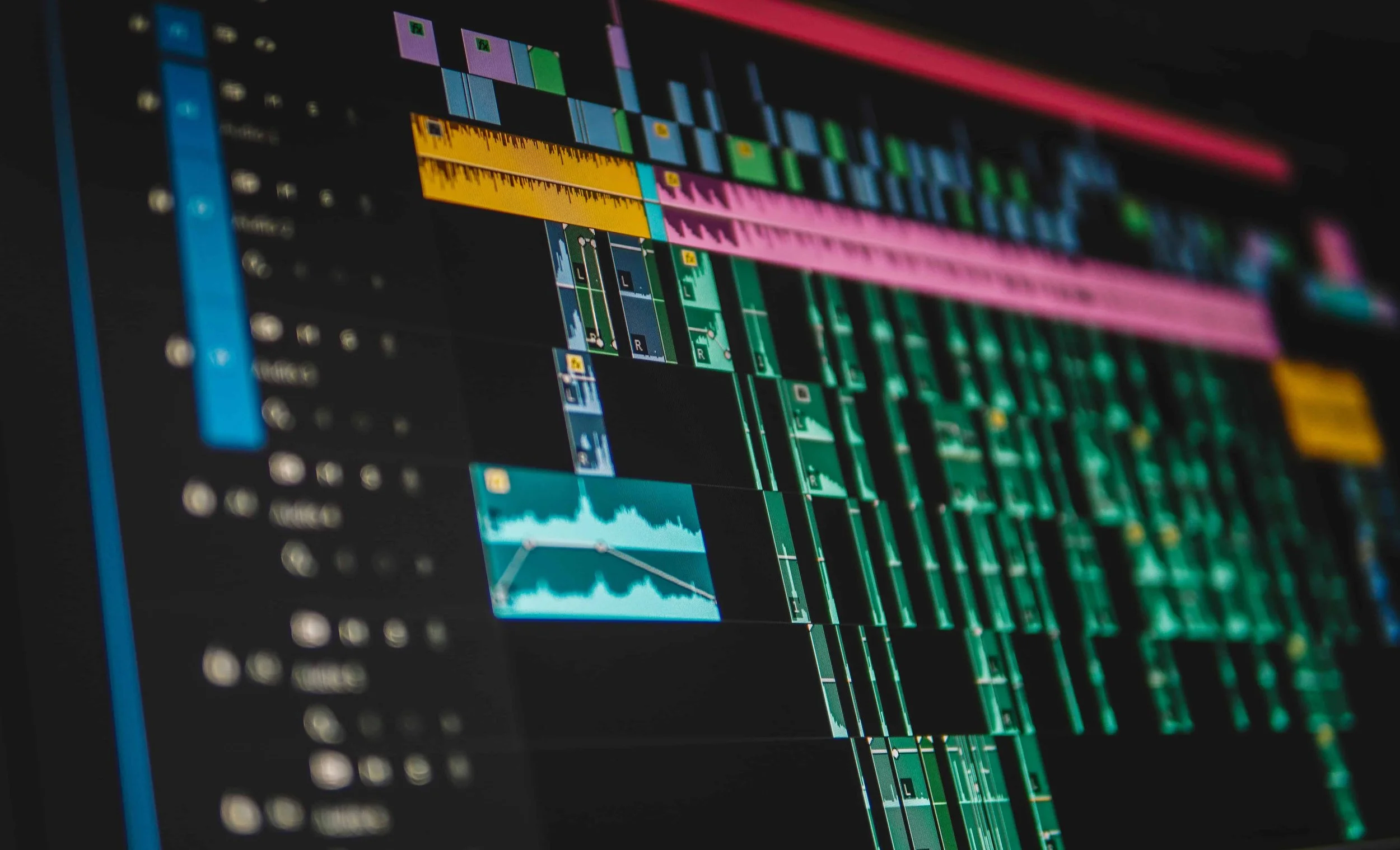 A video editing program window showing a timeline with multiple video and audio tracks, colorful clips, and editing tools in Adobe Premiere Pro.