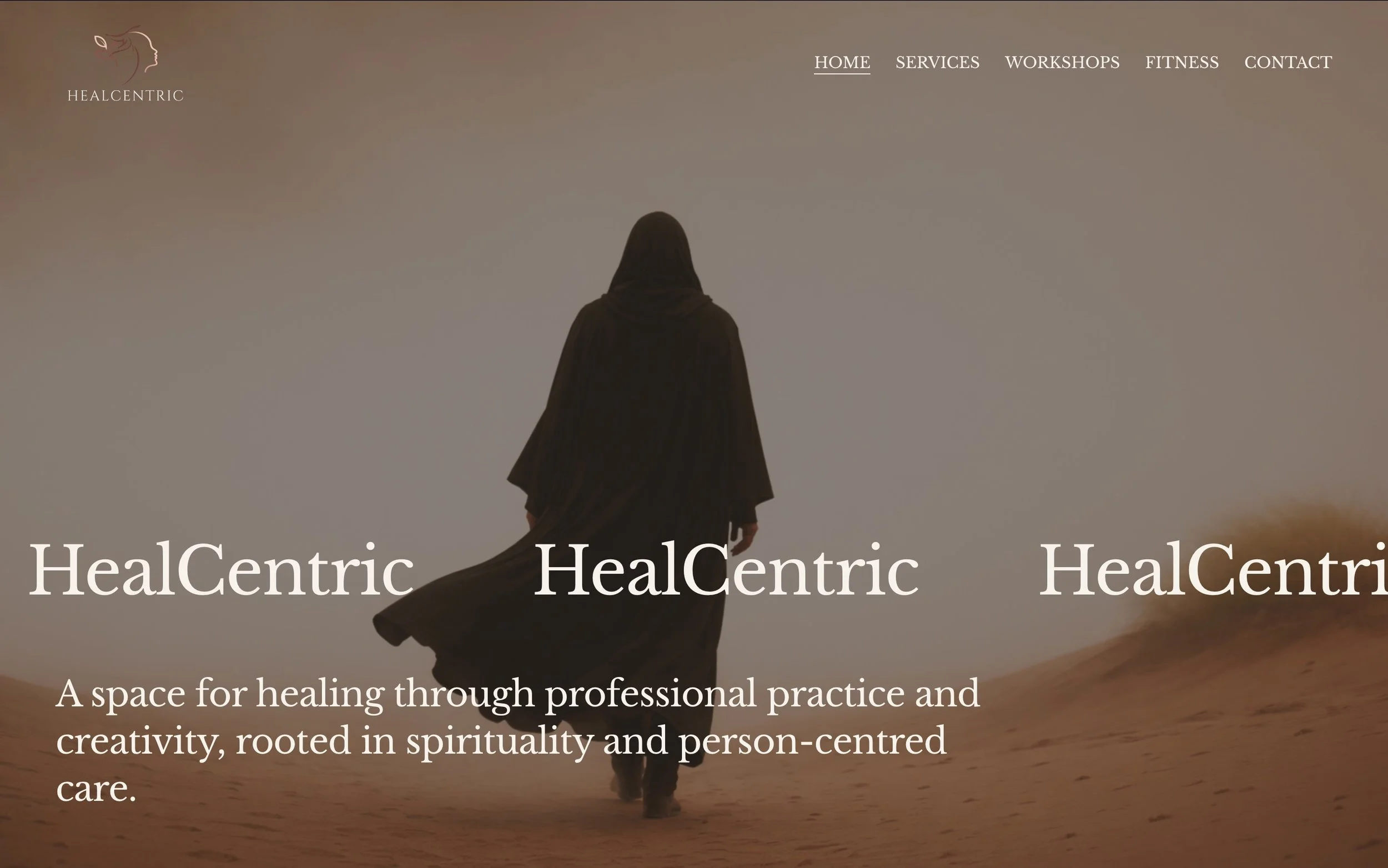 A person wearing black clothing and a head covering walking in a desert at sunset or sunrise.