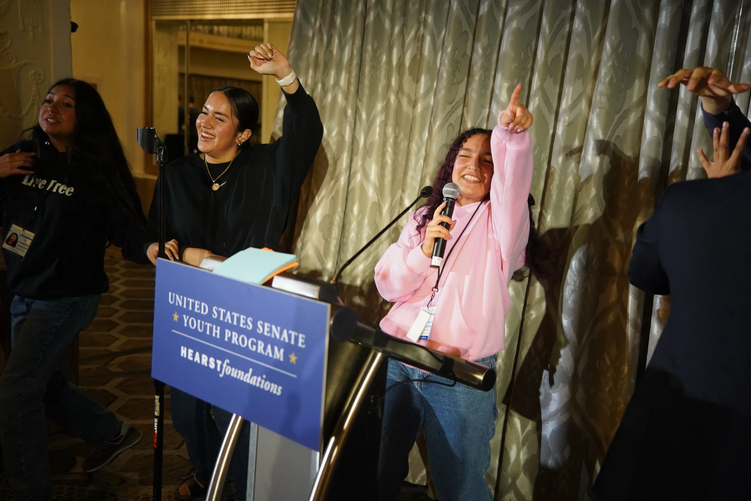 2026 - Singing to "Baby" by Justin Bieber, Arianne Medina (MA) does the karaoke portion of her campaign with the help of background dancers, Elani Trejo Guerrero (IL), and Catalina Gutierrez (TX) at the Mayflower Hotel on March 11. At the United Stat