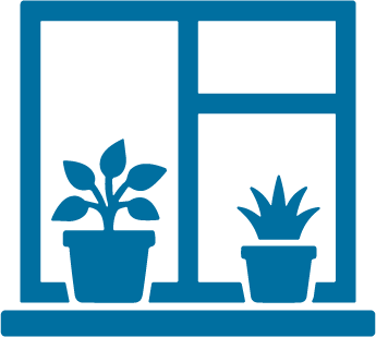 View of two potted plants on a windowsill, with a window frame and curtain in the background