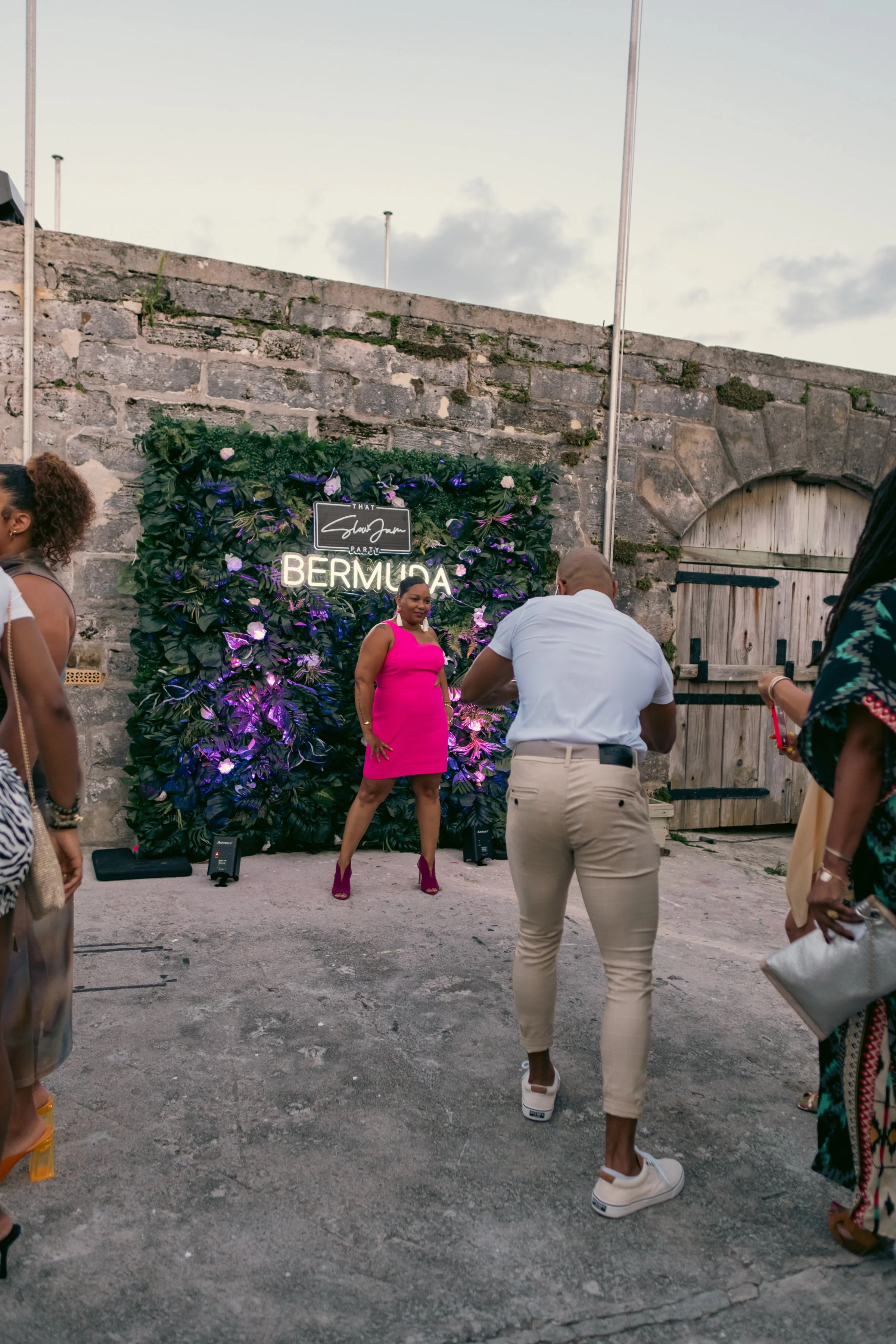 A guest posing at a That Slow Jam Party Bermuda photo moment during an outdoor R&B destination event.