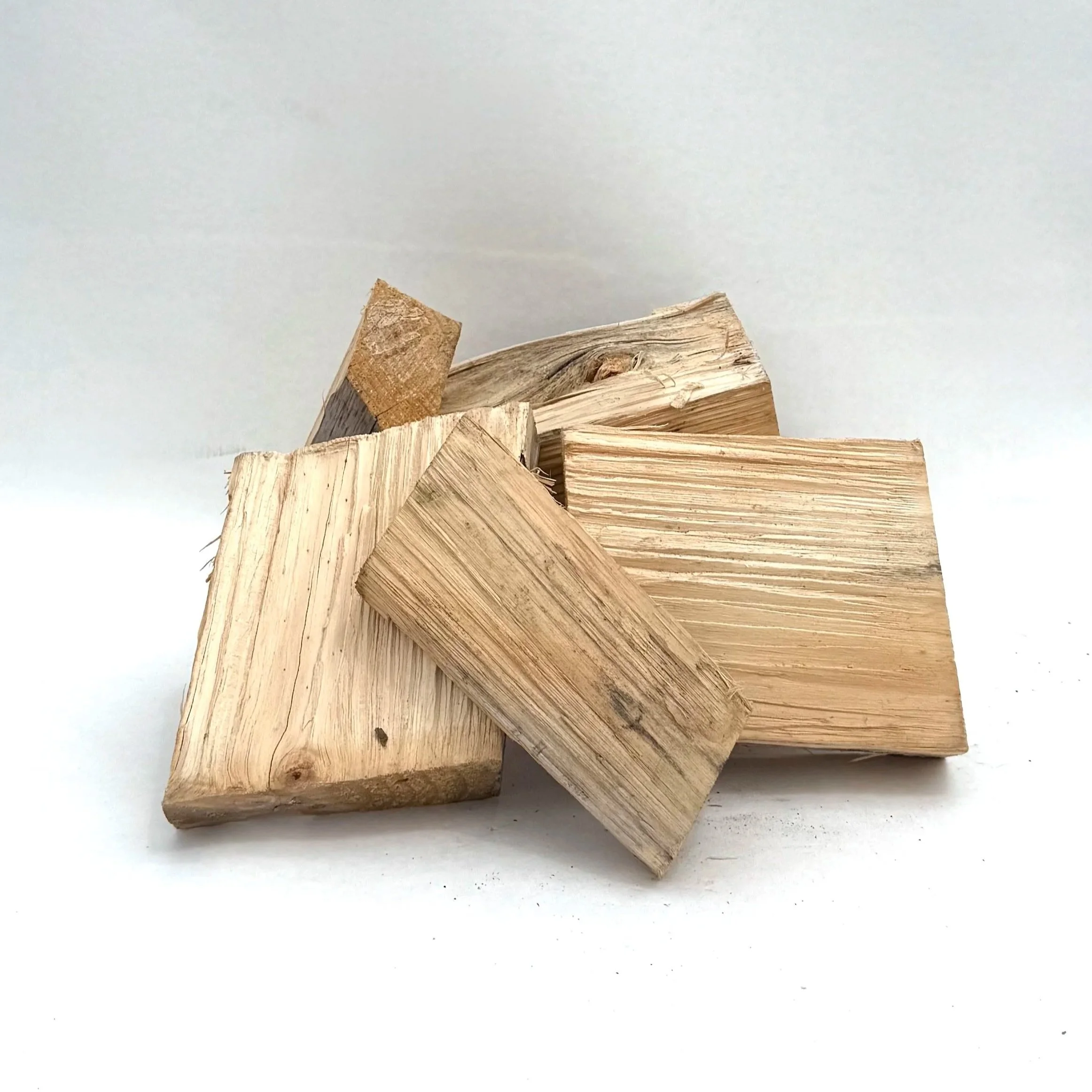 A collection of chopped firewood pieces on a white surface.