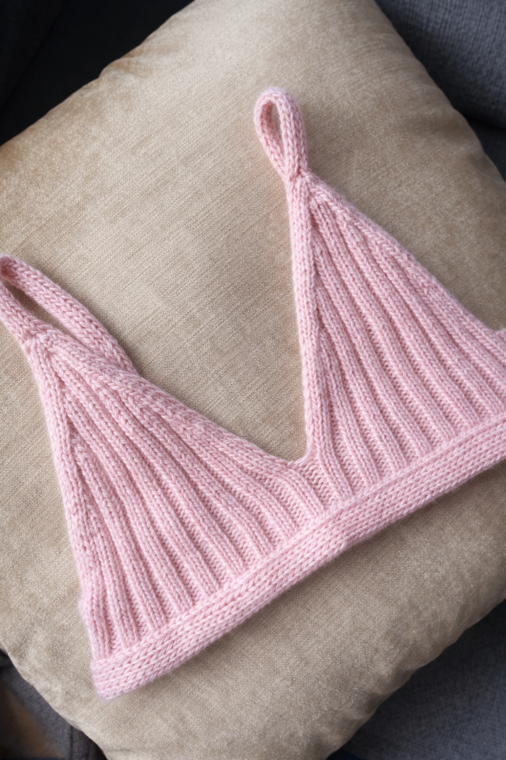 Soft pink bralette on cream pillow.png