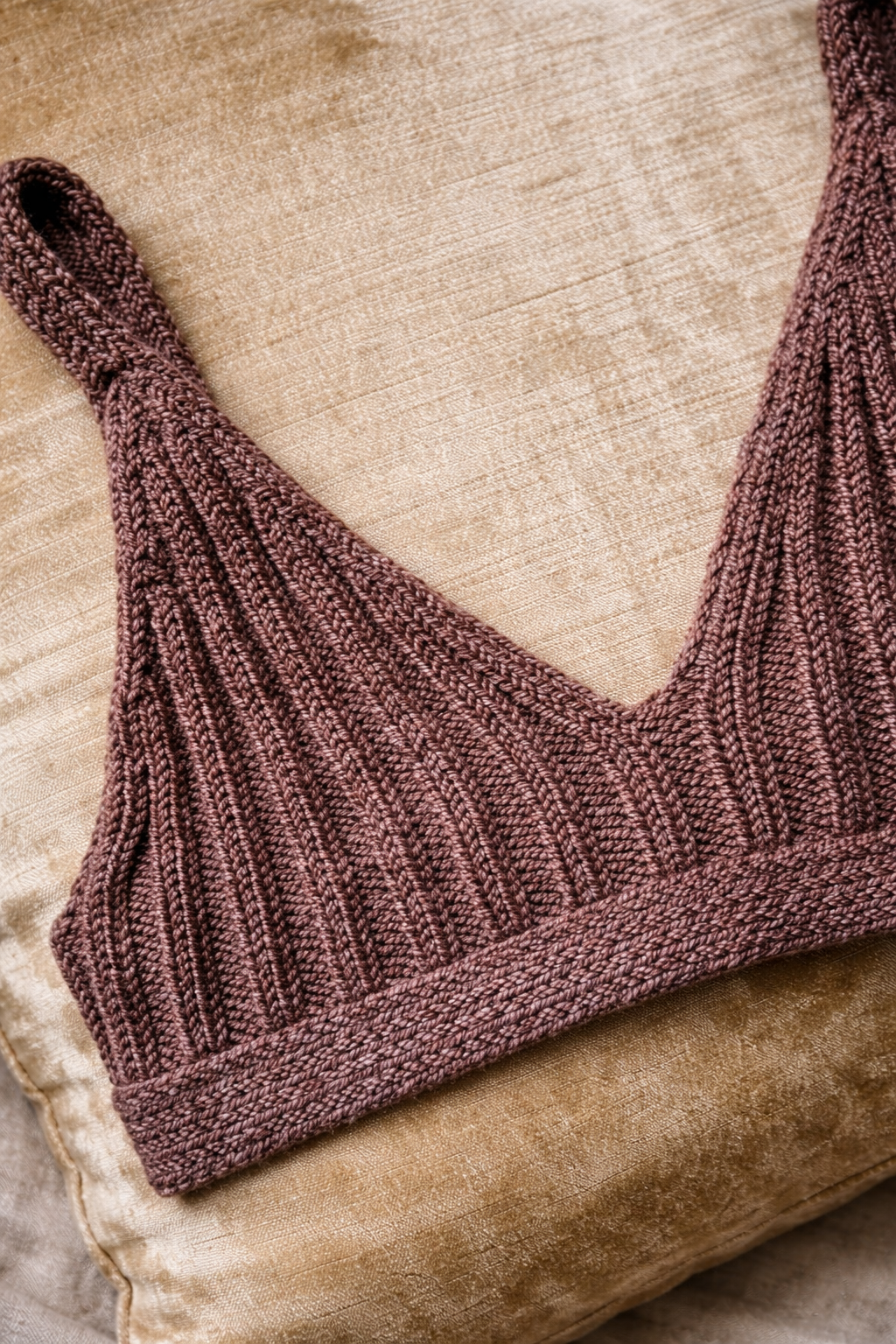 Ribbed knit bralette on textured pillow.png