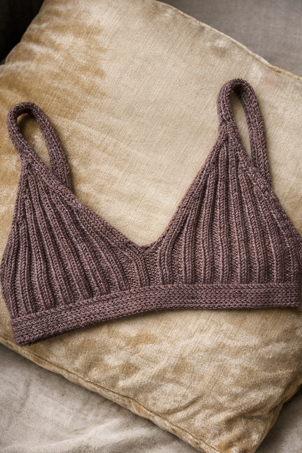 Knitted bralette on velvet pillow.png