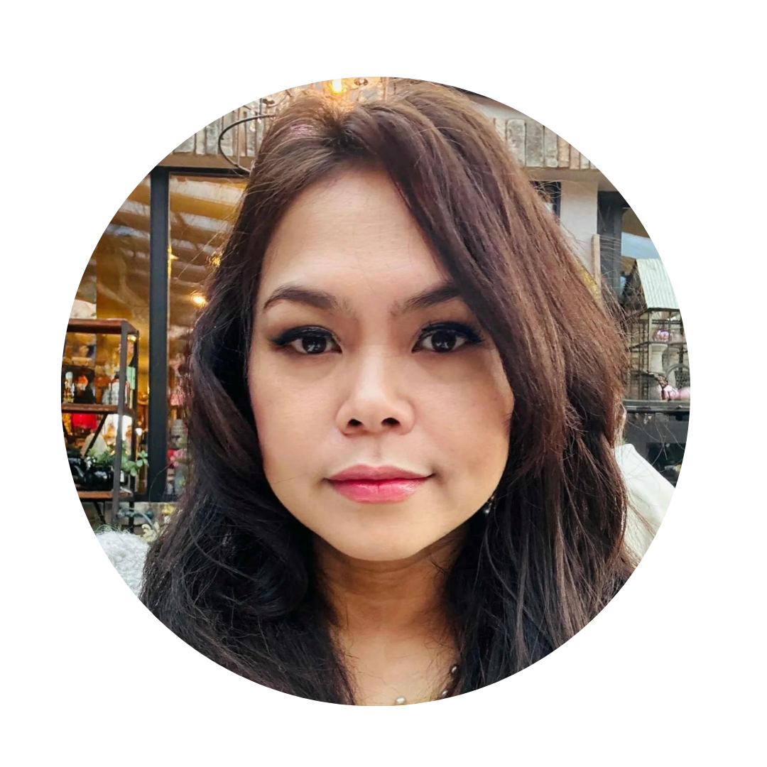 Close-up of a woman with shoulder-length dark hair, makeup, and a neutral expression, in an outdoor urban setting