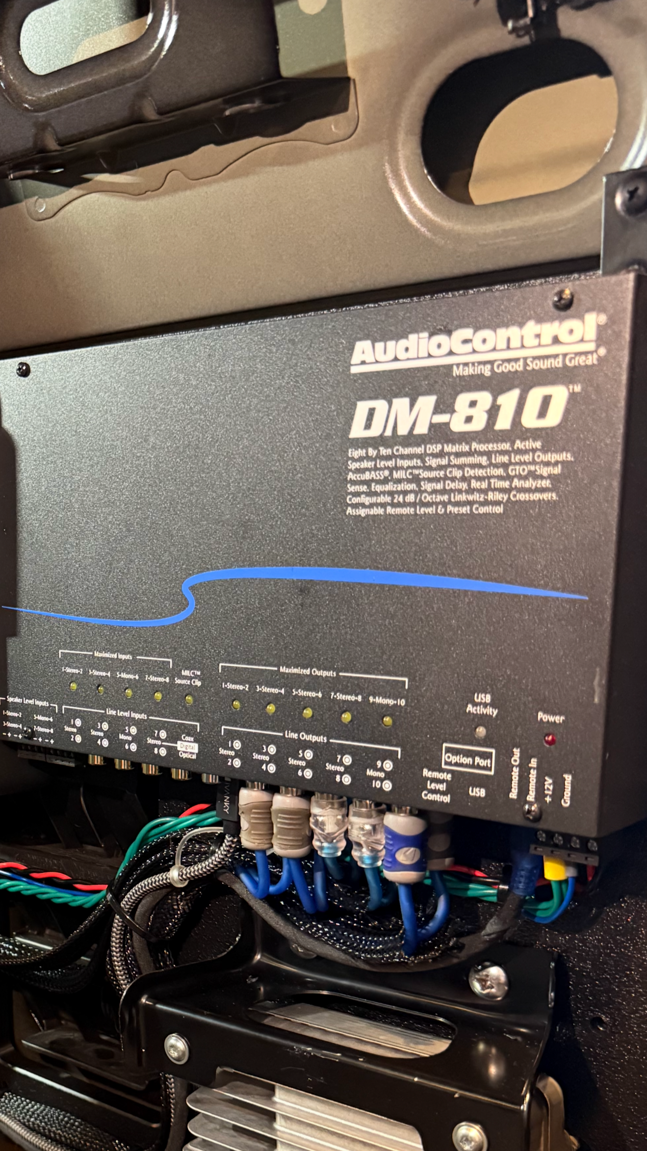 Close-up of an Audiocontrol DM-810 audio amplifier with various cables connected at the bottom.