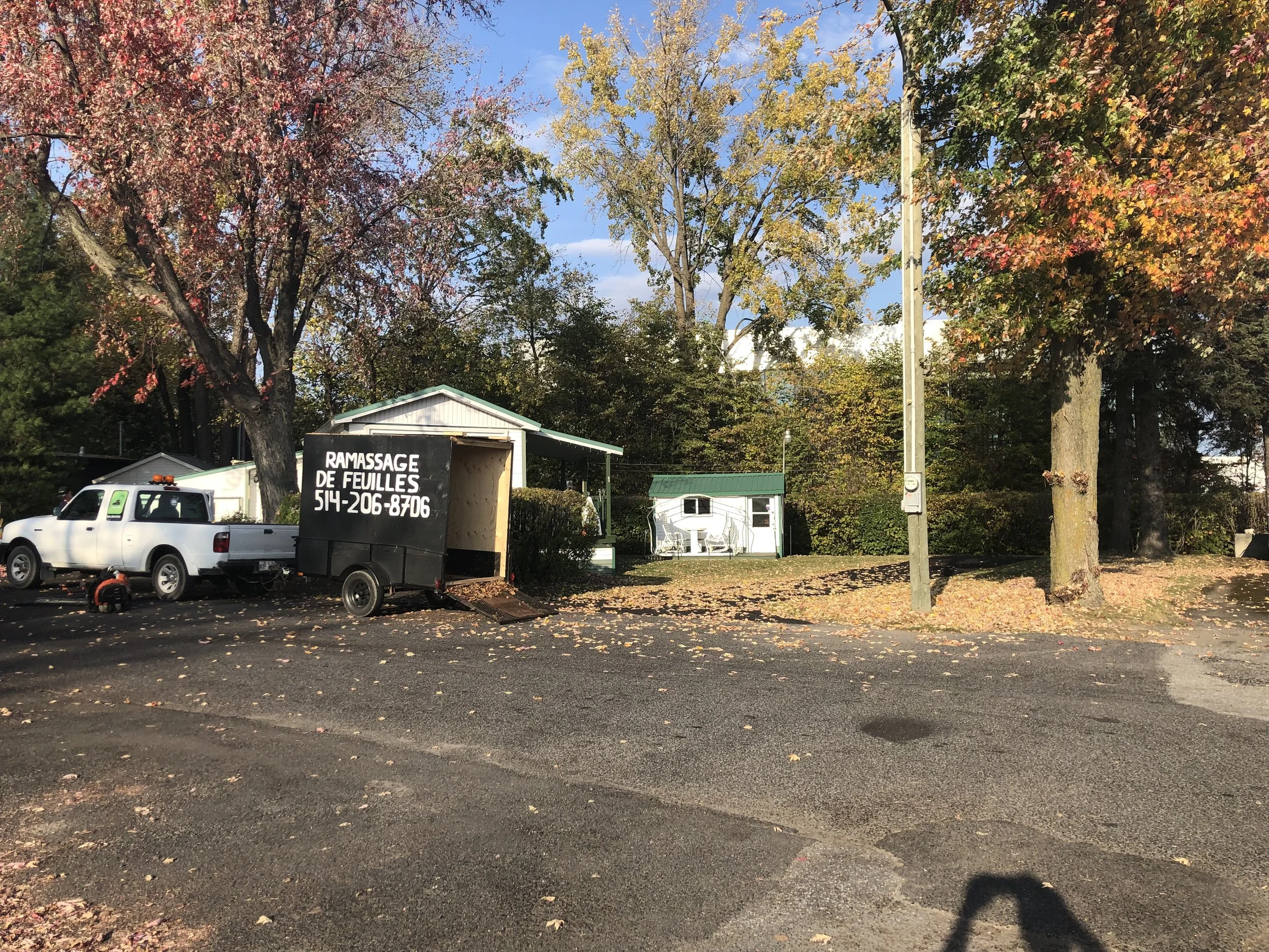 Un camion de paysagement et une remorque qui font du ramassage de feuilles à l'automne et une fermeture de terrain à Boucherville.