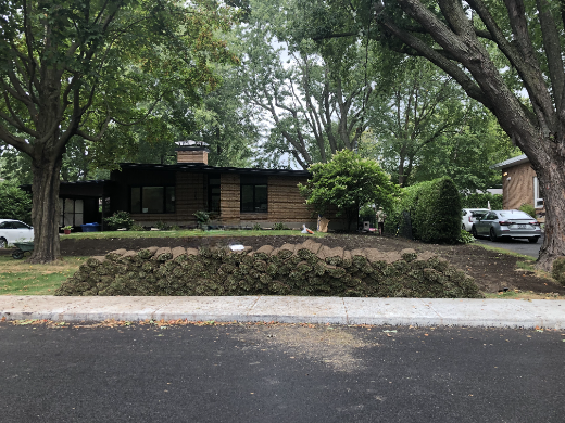Des rouleaux de tourbe devant une maison à St-Bruno-de-Montarville entourée de grands arbres.