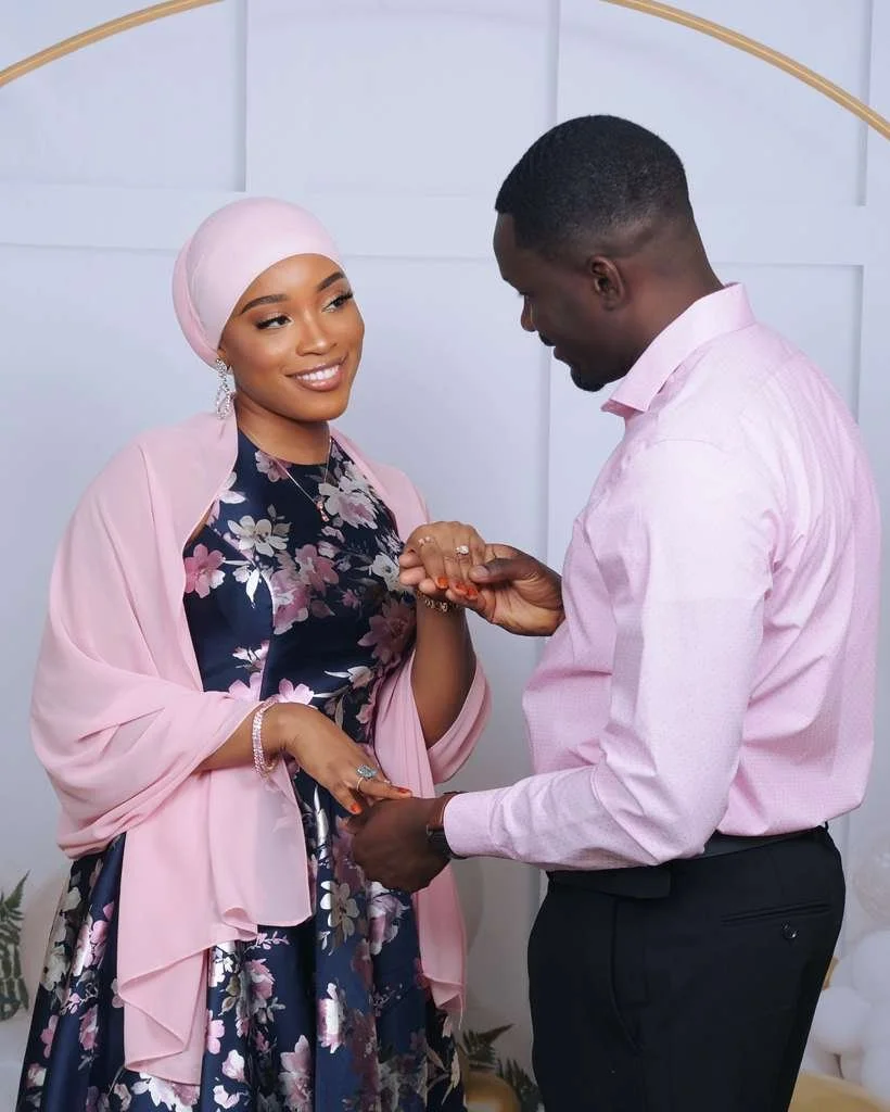 A couple in formal attire exchanging rings during a wedding ceremony.