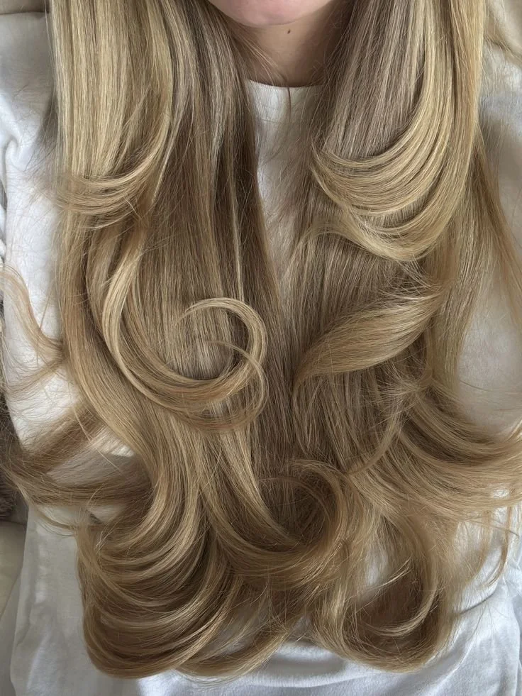 Close-up of long, blond, wavy hair with voluminous curls.