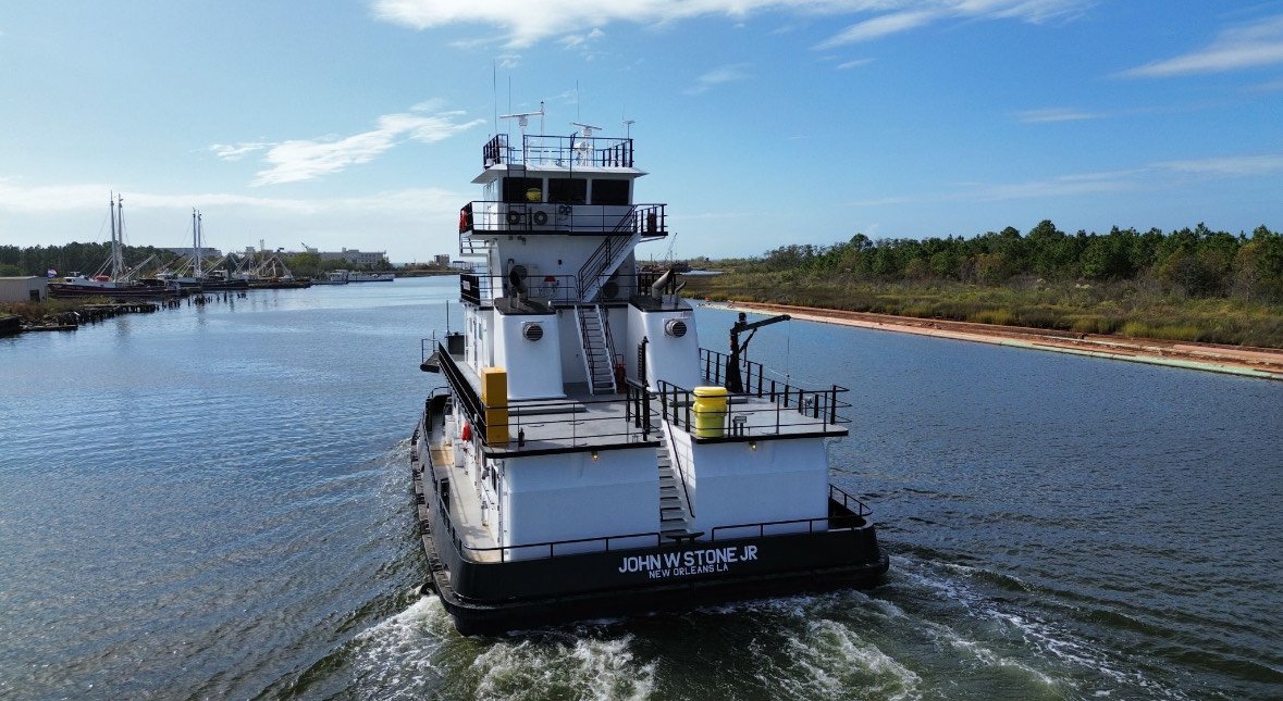 A tugboat named John W. Stone Jr. navigating a waterway near New Orleans, LA.