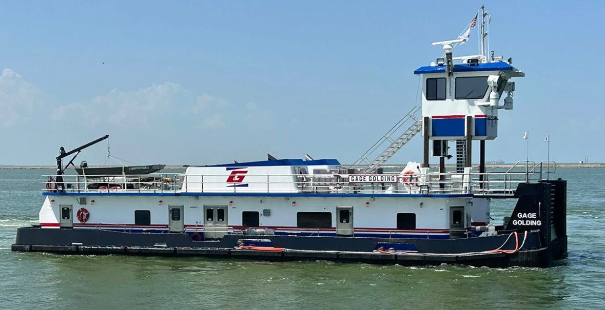 A tugboat named GAGE GOLDING on the water with a blue sky and some clouds in the background.