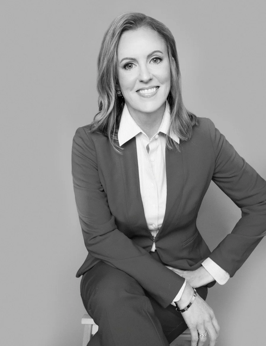 Professional headshot of Charissa Simmons, leadership writer and executive, wearing a business suit against a neutral background.