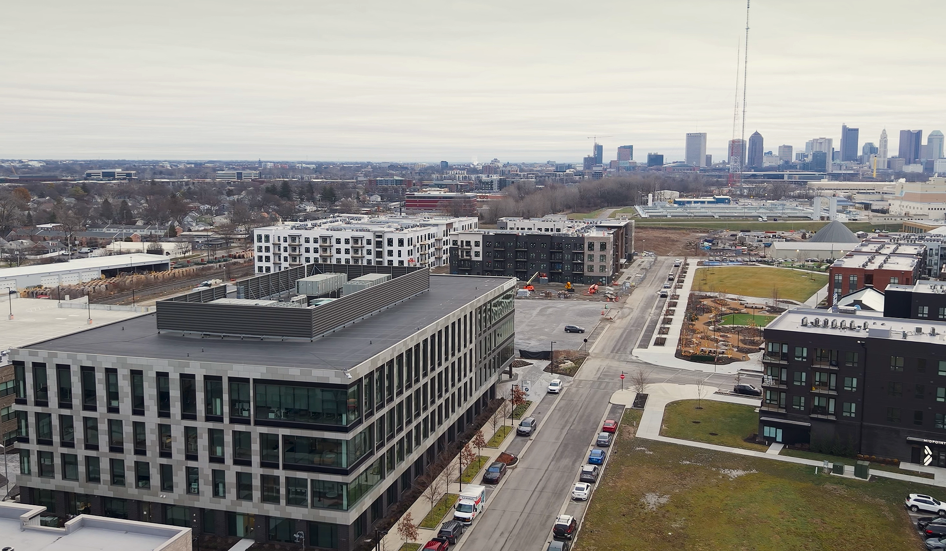 A cityscape view of buildings, roads, and a distant skyline with a cloudy sky.