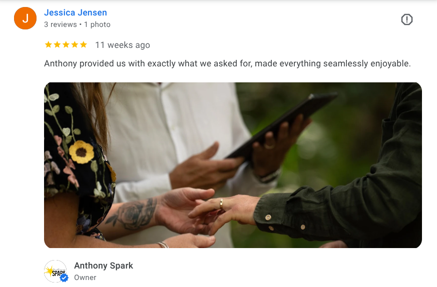 Bride and groom exchanging wedding rings outdoors, with Anthony Spark.