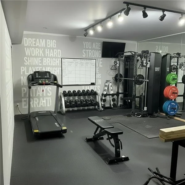 A modern kitchen with a stone accent wall, dark cabinetry, and built-in appliances, including a stainless steel oven and wine fridge, and recessed lighting.