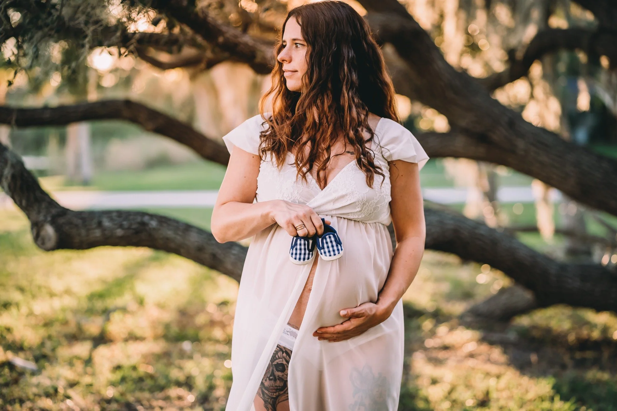 Maternity photo with mom holding baby's shoes in Rockledge, FL