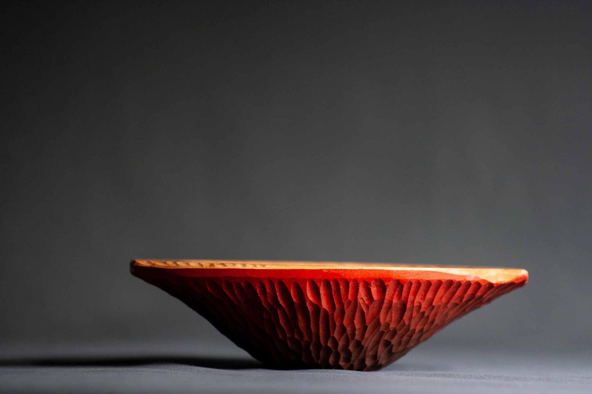 Huracán Bowl | With a shape inspired by hurricanes, this handled bowl features dramatic gouged texture with red ombre paint on the outside. Carved in cherry. 