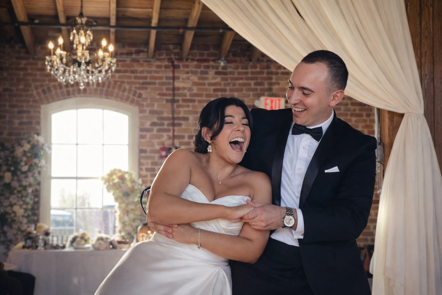 Bride and groom laughing together indoors at an elegant Greensboro wedding reception.