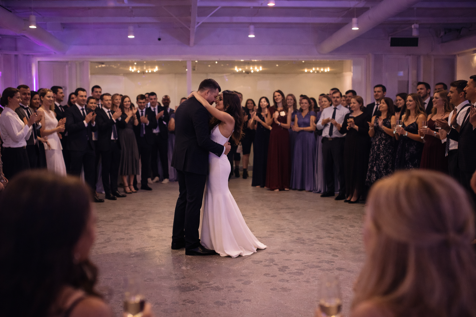 First dance surrounded by guests in a softly lit ballroom wedding reception in Cary, North Carolina.