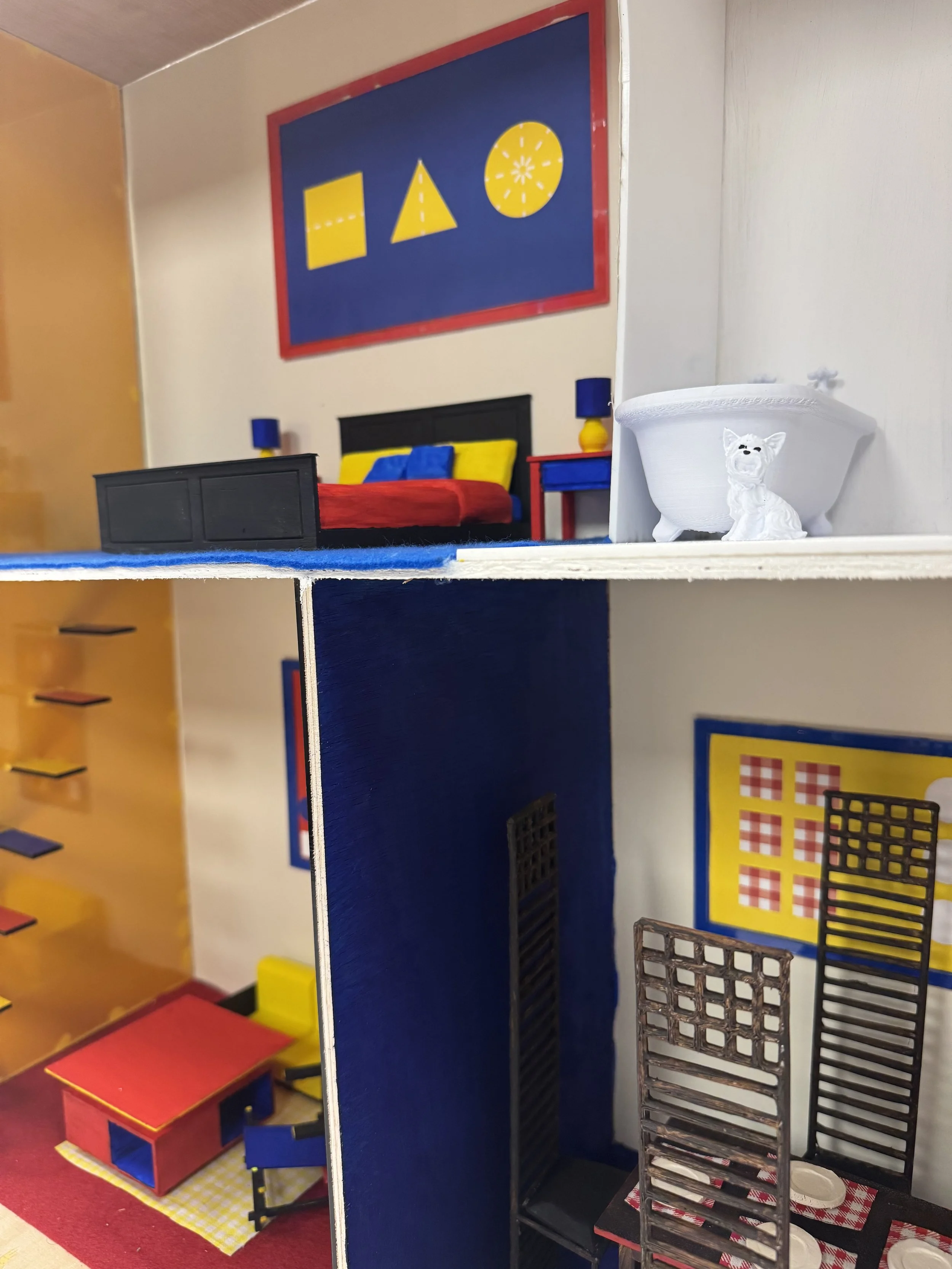 Close-up of a multi-story dollhouse with bedroom and living room decorated with colorful furniture, wall art, and small accessories.