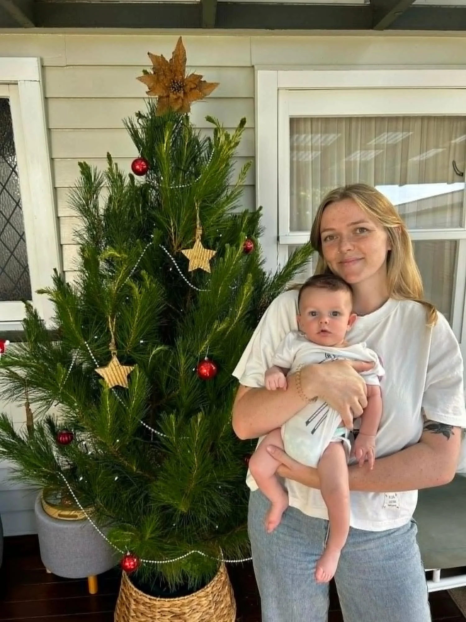 Ruby Hall smiling, holding her new baby.