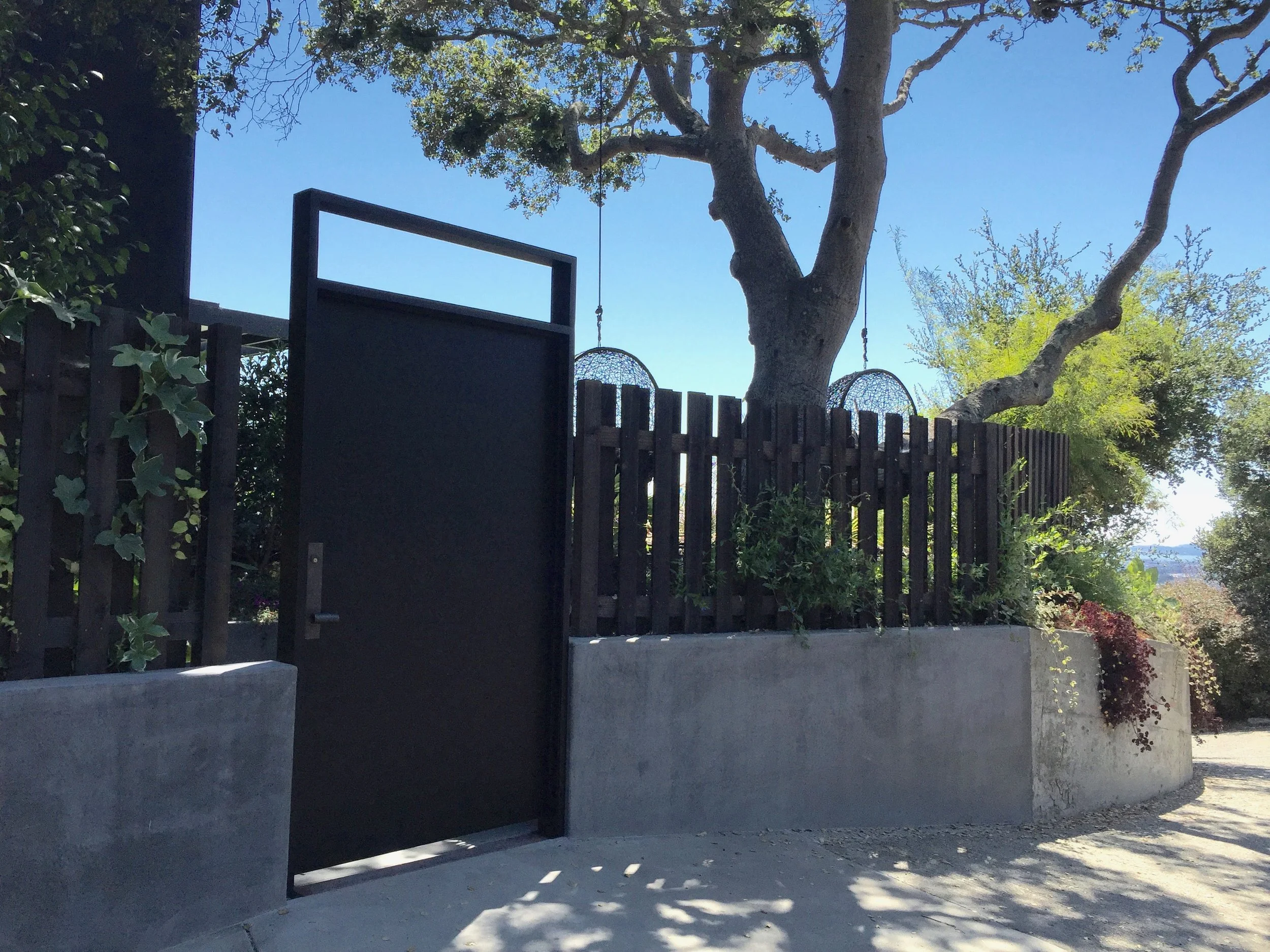   Front door entry gate   This gate adds an elegant and sturdy accent this home. The 4'x7' steel door is identical to the main entry door, and the faux window matches the proportions of the home's windows, adding architectural continuity to the exter