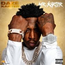 Close-up of a young man with tattoos, multiple gold chains, and a watch, holding his head with both hands, with the text 'Mr. Karter' on the top right and the name 'Da 2 E Karter' on the top left.