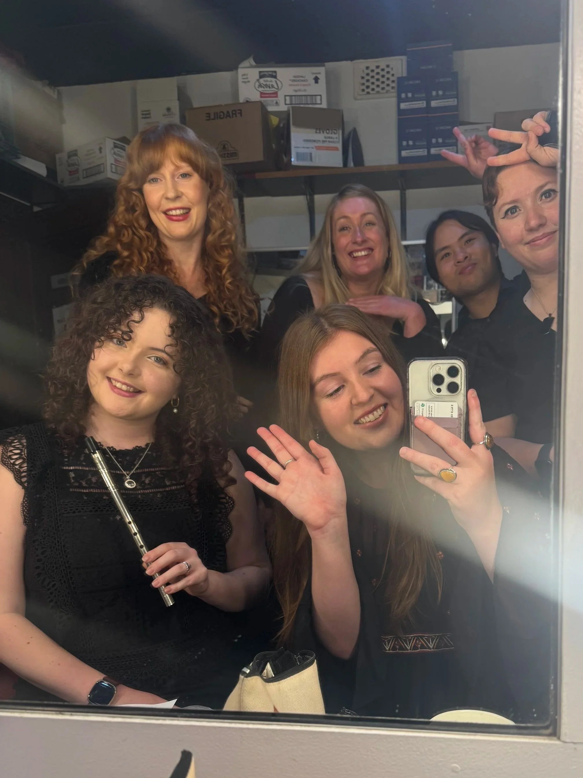 Andrea and friends after a gig in the green room of the Ellington Jazz Club. Andrea is holding a tin whistle while all six women pose for a mirror selfie.