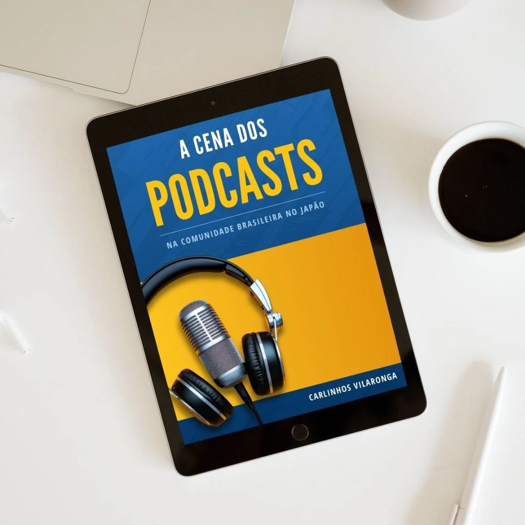 Capa de livro ou capa digital sobre podcasts, com um microfone e fones de ouvido, em um tablet, com fundo azul e amarelo, ao lado de uma xícara de café e outros objetos.