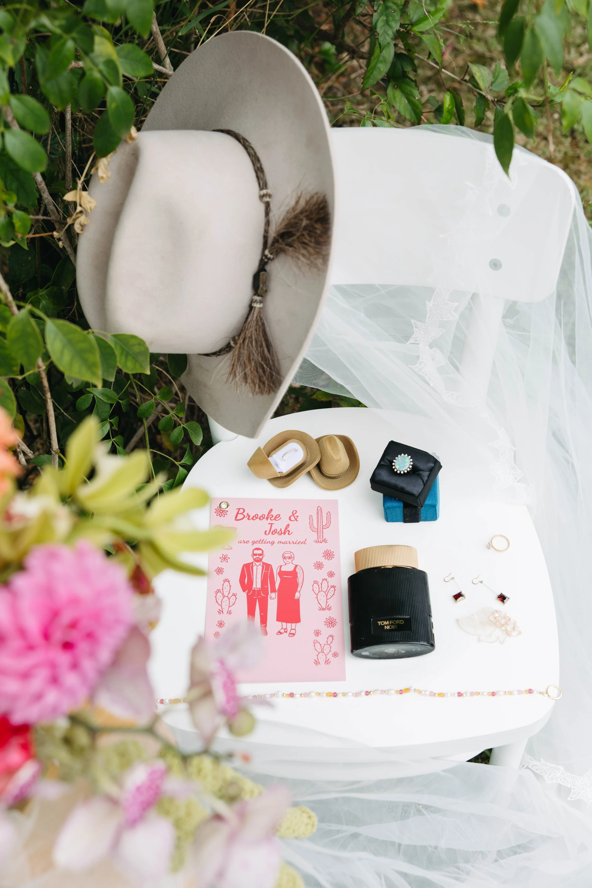 Bridal details with a feathered hat, veil, jewellery and invitation, Barrington Coast wedding