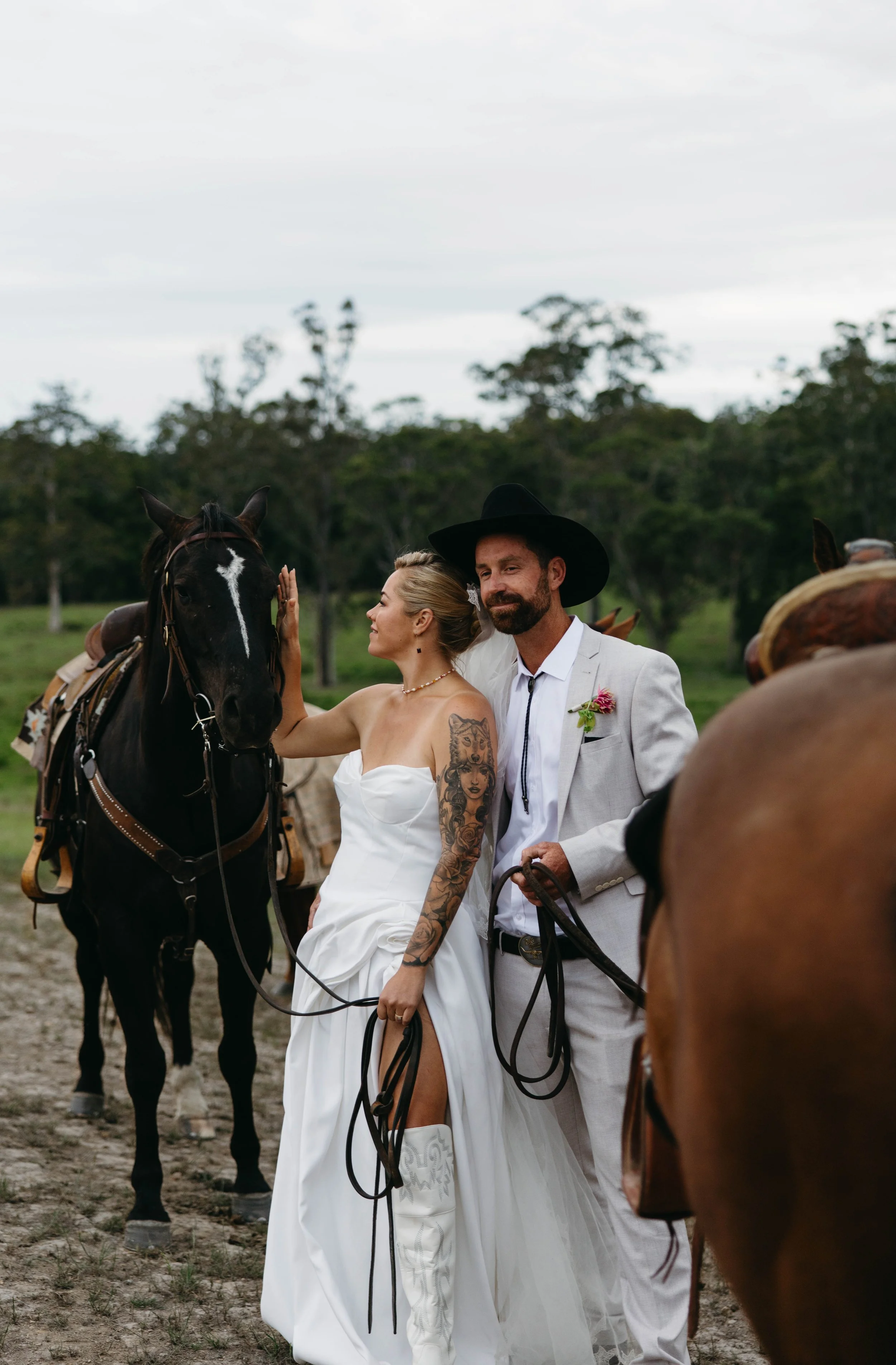 Bride and groom with horses at a rural NSW wedding