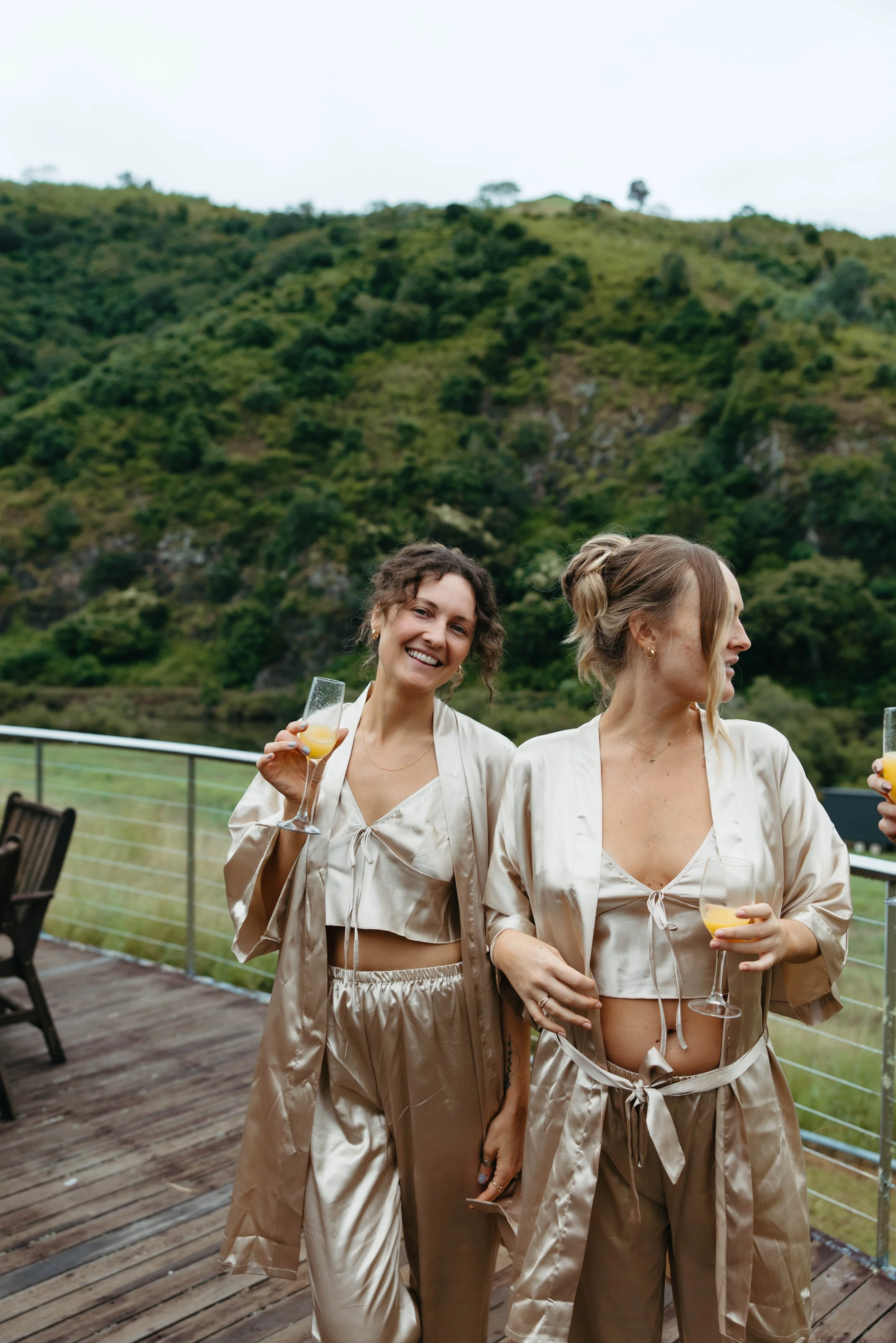 Bridesmaids in satin with drinks overlooking the hills at Longview Farm, Mid North Coast