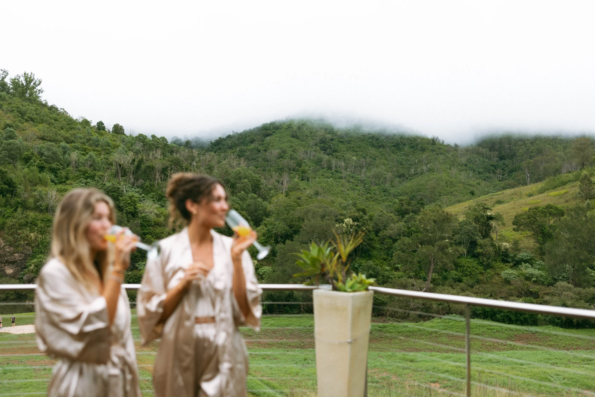 Bridesmaids enjoying drinks with a green hillside view at Longview Farm, Mid North Coast wedding
