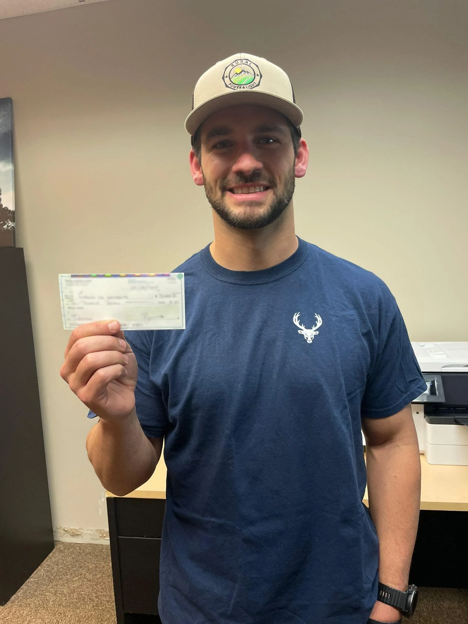 Ben Wright holding a check for Growing the Grassroots startup funds