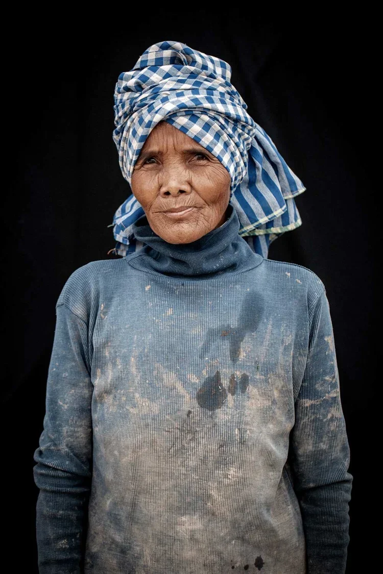 Srey Nher age unknown: "My current job is to harvest morning glories from the lotus swamp in front of the school. I sell the stems at the vegetable stand in the afternoon. This is how I make a living. During the war I was forced to dig and haul a lot